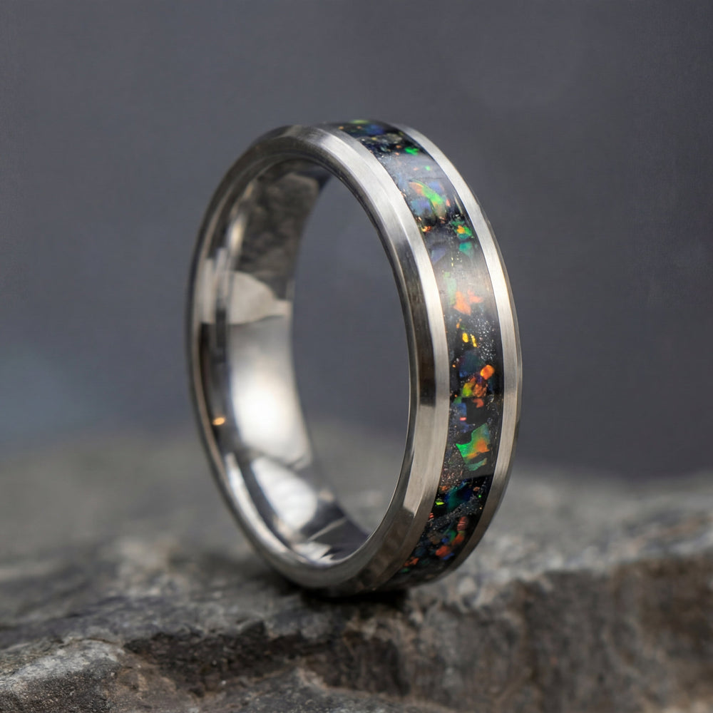 Silver ring with opal inlay on a dark stone surface