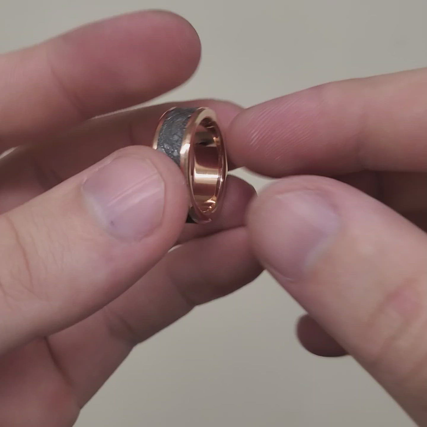 Meteorite and rose gold men's wedding ring.